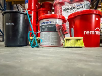 Eimer und Werkzeuge stehen bereit auf Lagerboden, zeigen Bauchemieprodukte für professionelle Anwendungen Eimer und Werkzeuge stehen bereit auf Lagerboden, zeigen Bauchemieprodukte für professionelle Anwendungen